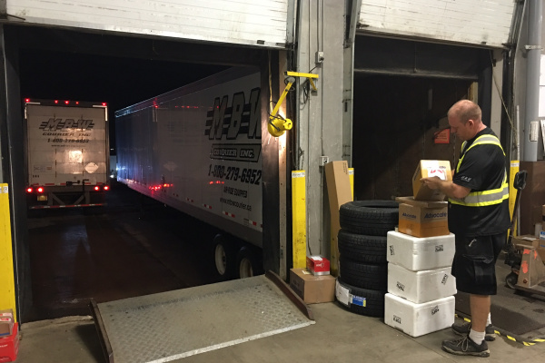 Man checking boxes before loading them onto MBW trucks